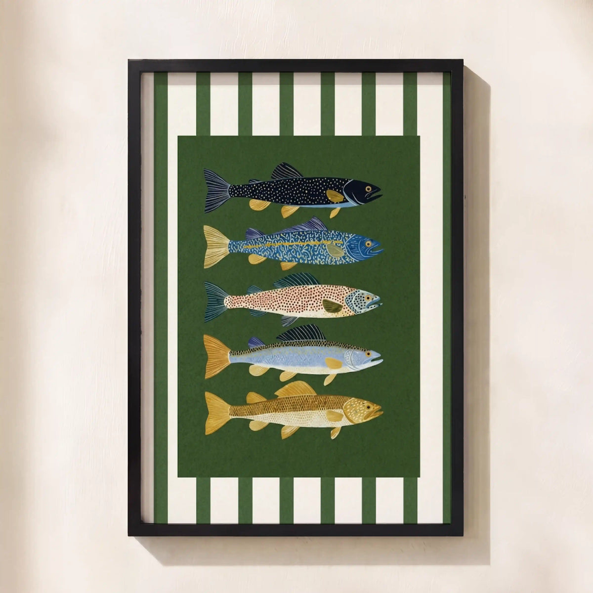 Framed wall art featuring five illustrated fish on a dark green background with white vertical stripes, hung on a light beige wall.